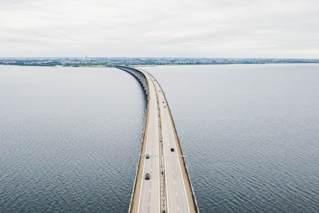 Aerial view of a long bridge crossing water under an overcast sky